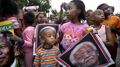 South African children celebrate Nelson Mandela's life in the street outside his old house in Soweto, Johannesburg, on Friday. Ben Curtis / AP Photo