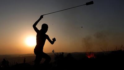 A Palestinian demonstrator uses a sling to hurl stones at Israeli troops near Ramallah in the occupied West Bank September 4, 2018. Reuters
