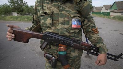 A pro-Russian armed militant with a sticker which reads “Donetsk People Republic” guards a checkpoint blocking the major highway which links Kharkiv, outside Slovyansk, Ukraine. Ukrainians vote Sunday in an early presidential election that could be a crucial step toward resolving the country’s crisis, but separatists in the east are threatening to block the vote. Alexander Zemlianichenko/AP Photo
