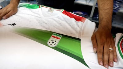 An Iranian shopkeeper shows Iran's national football jersey in his shop in Tehran on May 8, 2026. AFP