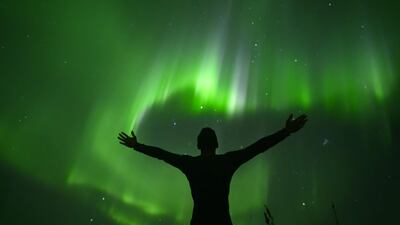 Indonesian surfer Edi Siswanto stands before the Northern Lights in Unstad, Lofoten Islands, beyond the Arctic Circle. AFP