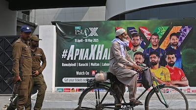 A cyclist rides past a hoarding outside the Gaddafi Cricket Stadium in Rawalpindi. Pakistan's showpiece PSL tournament is postponed. AFP