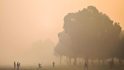 Smog adds atmosphere to a cricket game at a park in New Delhi, the capital of India. AFP