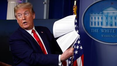 Then-president Donald Trump holds up papers in the White House in 2020, in Washington. AP