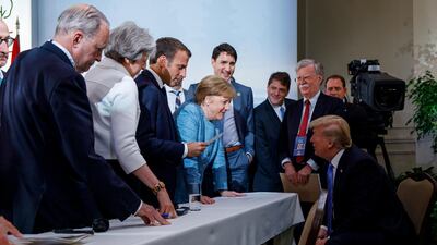 Canada's Prime Minister Justin Trudeau and G7 leaders Britain's Prime Minister Theresa May, France's President Emmanuel Macron, Germany's Chancellor Angela Merkel, and US President Donald Trump discuss the joint statement following a breakfast meeting on the second day of the G7 meeting in Charlevoix city of La Malbaie, Quebec, Canada, June 9, 2018. Handout via Reuters Photo
