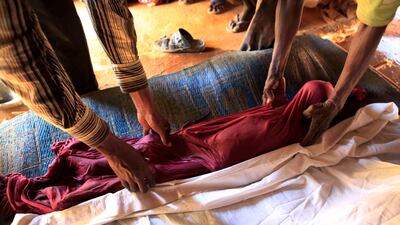 July 12, 2011: Men prepare the body of Aden Ibrahim for burial in accordance with Somali tradition, inside the makeshift shelter where Aden's family lives amongst other newly-arrived Somali refugees, on the outskirts of Ifo II Camp, outside Dadaab, Kenya.???