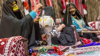 Women display the art of traditional Emirati weaving in the souq at the third Liwa Ajman Date Festival, at Emirates Hospitality Hall near Ajman City Centre. The three-day festival celebrating the UAE’s rich heritage began on Wednesday. Antonie Robertson / The National