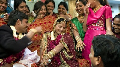 An Indian bride reacts as her husband prepares to feed her during a ritual at a wedding ceremony. Sam Panthaky / AFP