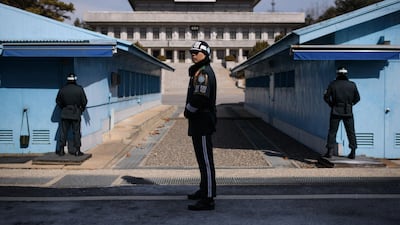 A South Korean soldier, centre, stands guard before the military demarcation line and North Korea's Panmun Hall, in the truce village of Panmunjom. Ed Jones / AFP Photo