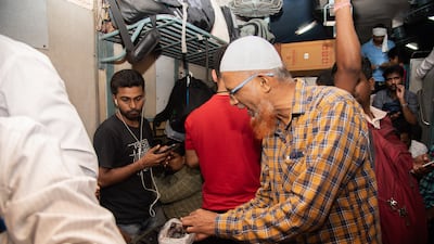 Teacher Ahmed Najeeb, 54, offers dates to fellow passengers during iftar aboard the Flying Rani commuter train in western India. All photos: Mahendra Parikh for The National