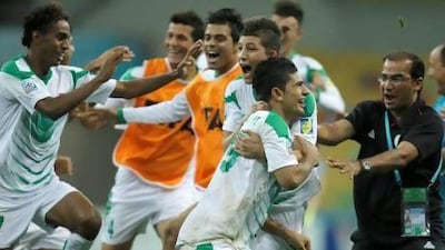Iraq’s Farhan Shakor, No 19, celebrates with teammates and staff after scoring the decisive penalty in the shootout on Sunday.