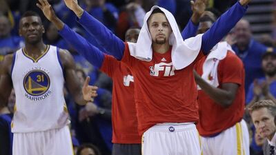 Golden State Warriors guard Stephen Curry celebrates from the sideline as he sat toward the end of his team’s blowout win over the San Antonio Spurs. Marcio Jose Sanchez / AP