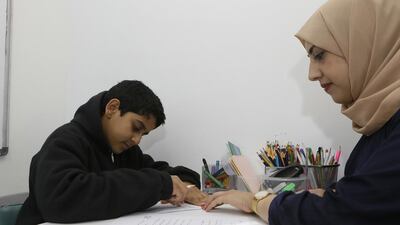 Zaid Al Jaberi, 11, an Emirati student who has learning difficulties, with his Arabic teacher Alaa Shatnawi at the Taleem Centre. Jeffrey E Biteng / The National
