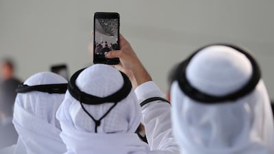 Attendees take a picture of French Prime Minister Edouard Philippe during his speech at Louvre Abu Dhabi. Karim Sahib / AFP