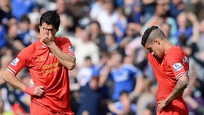 Liverpool’s Uruguayan striker Luis Suarez, left, and Liverpool’s Brazilian midfielder Philippe Coutinho, right, react after Chelsea’s Brazilian midfielder Willian (not pictured) scored his team’s second goal during the English Premier League football match between Liverpool and Chelsea at Anfield Stadium in Liverpool, northwest England, on April 27, 2014. AFP PHOTO / ANDREW YATES