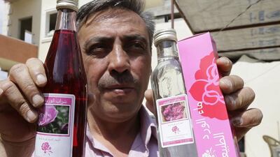 A Syrian man shows a brand of rose water.