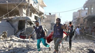 Syrian volunteers carry an air strike victim on a stretcher in the rebel-held area of Al Heluk in Aleppo. Thaer Mohammed / AFP