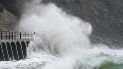 Waves crash over the promenade during rain and strong winds in Folkestone, Kent. PA