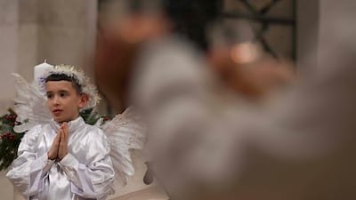 A Kosovar child dressed as an angel prays during Christmas Eve Mass, at Mother Teresa Cathedral in Pristina. AFP