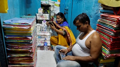Kolkata shopkeepers watch election results on their mobile phones inside their shop. Reuters