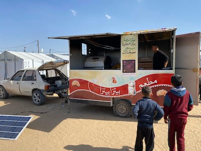 Children wait eagerly in front of Mohammed Al Amarin's mobile kitchen. Mohammed Abu Amra for The National