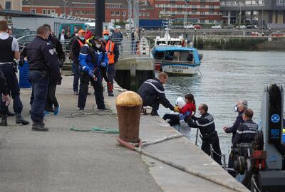 French Gendarmes and police assist migrants, including five children and a baby, who tried to reach England by crossing the Channel, and who were rescued off the French port city of Calais on May 16. Bernard Barron / AFP