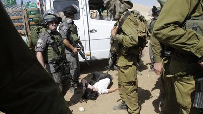 French diplomat Marion Castaing lays on the ground after Israeli soldiers carried her out of her truck containing emergency aid on Friday. Abed Omar Qusini / Reuters