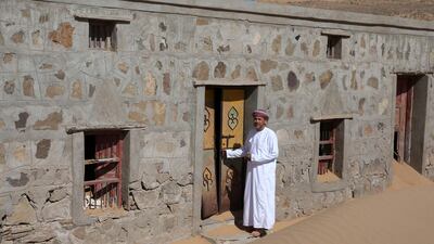 Mohammed al-Ghanbousi, a former inhabitant of Wadi al-Murr, stands next to his abandoned house in the Omani village. AFP