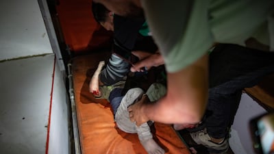Emergency services attend to a child wounded in an Israeli attack on a building sheltering displaced Palestinians in Gaza city. EPA