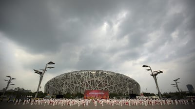 Participants dance at a gathering to watch the announcement of the 2022 Winter Olympics. Mark Schiefelbein / AP Photo