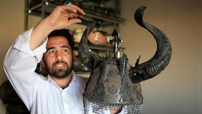 Mohammed Daoud Ghazniwall, presents an antique helmet from Afghanistan one of the stalls in the Sheikh Zayed Heritage Festival. Ravindranath K / The National