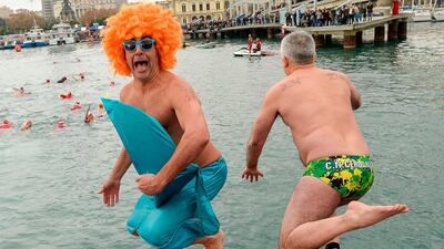 A participant in a mermaid costume jumps into the water during the 108th edition of the 'Copa Nadal' (Christmas Cup) swimming competition in Barcelona's Port Vell. AFP PHOTO / Josep LAGO