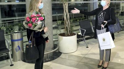 She meets her mother Christina at the airport - and remembers to keep her distance after an international flight
