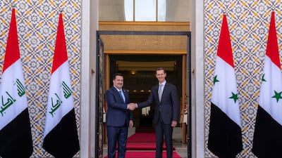 Syrian President Bashar Al Assad, right, shakes hands with Iraqi Prime Minister Mohammed Shia Al Sudani ahead of talks in Damascus on Sunday. SANA