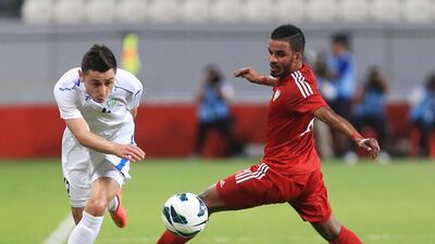 Uzbekistan’s Tursunov Sanjar, left, gets the ball past Mahmoud Khamis Saeed Al Hammadi of the UAE during their international friendly at Mohammed bin Zayed stadium in Abu Dhabi on Tuesday night. Ravindranath K / The National