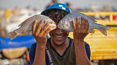 A youth poses with fish in Iraq's southern port city of Al Faw, 90 kilometres south of Basra near the Shatt Al Arab and the Gulf, on May 18, 2020. Hussein Faleh / AFP