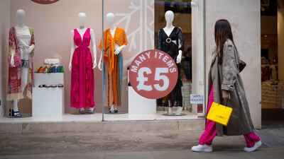 A shopper walks past a shop window advertising a sale in Oxford Street in London. EPA