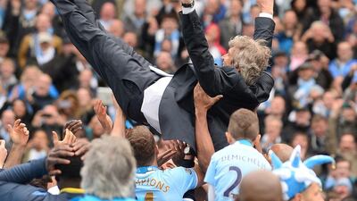 Manchester City manager Manuel Pellegrini is tossed into the air by his players as they celebrate after winning the Premier League title on Sunday. Andrew Yates / AFP