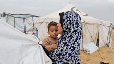 A woman holds a child at a shelter for displaced Palestinians in Khan Younis in the southern Gaza Strip, on April 2, 2026. Reuters