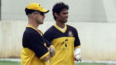 The Bangladesh cricketer Farhad Reza ,right, talks with coach James Siddons during a training session in Karachi.