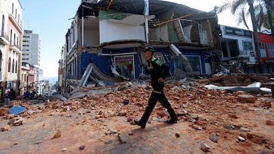 A police officer walks past debris in Manizales. AFP