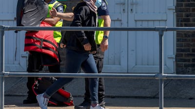 A migrant woman arrives in Dover, UK, after crossing the Channel on a small boat from France. Getty Images