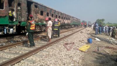 People and rescue workers gather near the site after a fire broke out in a passenger train and destroyed three carriages near the town of Rahim Yar Khan, Pakistan. Reuters