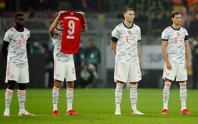 Bayern Munich's Thomas Muller holds the jersey of Gerd Muller as a tribute before the match against Dortmund. Reuters