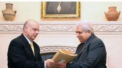 Cypriot lawyer Polys Polyviou (left) hands over a report to Cypriot president Demetris Christofias (at the presidential palace in Nicosia yesterday after a public commission into the causes of the explosion of confiscated Iranian munitions in July which killed 13 people and destroyed the island's largest power station. KATIA CHRISTODOULOU / EPA