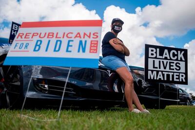 A supporter listens as former US President Barack Obama speaks at a Biden-Harris drive-in rally in Orlando, Florida on October 27. AFP