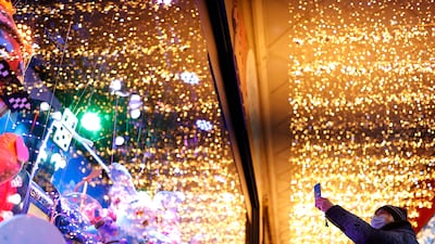 A pedestrian wearing a face mask looks at Christmas window displays in Paris, France. EPA