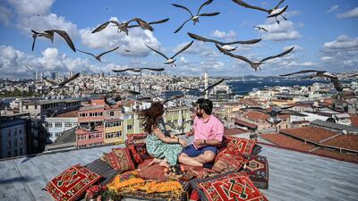 A couple sit on the terrace of a cafe in Istanbul as seagulls fly over them.A decrease in the value of the Turkish made the capital city appealing as a budget friendly European destination. AFP