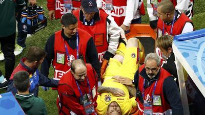 Romania's Denis Alibec is carried off the pitch. Max Rossi / Reuters