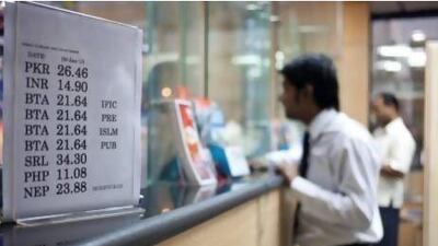 Customers send remittances to their home countries at an exchange in Deira, Dubai. With more than 130 exchange houses in the UAE, competition is intense. Razan Alzayani / The National